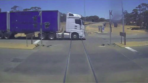 Watch the heart-stopping moment a freight train barely misses truck