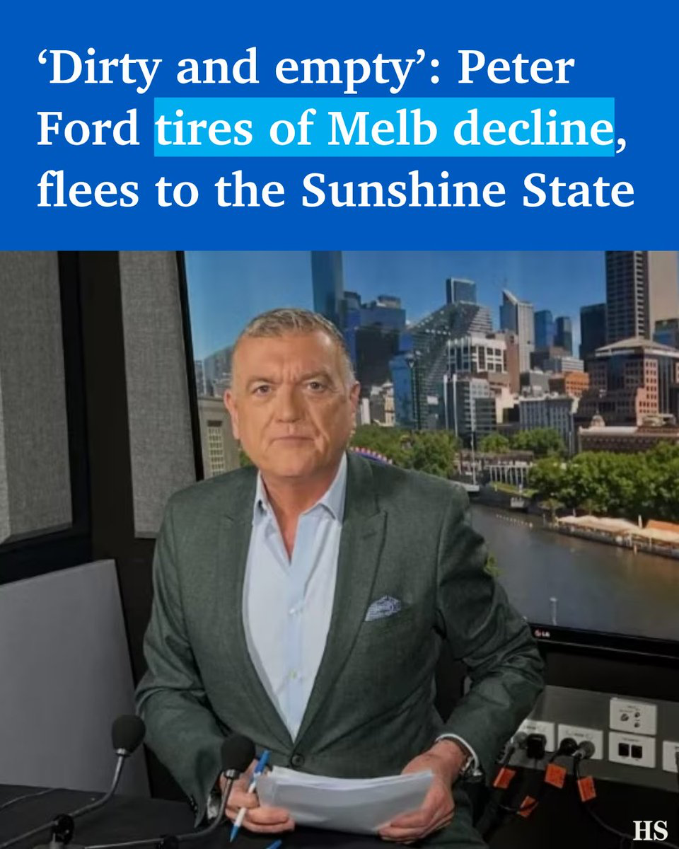 News anchor in a gray suit sits at a desk with papers, city skyline on a screen behind him; a bold blue headline overlays the image.