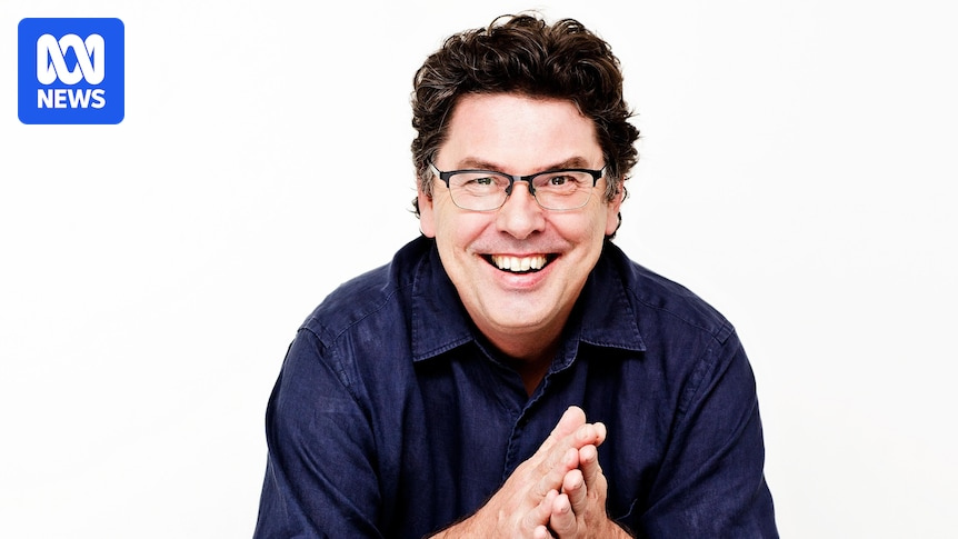 Smiling man with glasses in a navy shirt, hands clasped, against a white studio backdrop with an ABC News logo in the top-left corner.