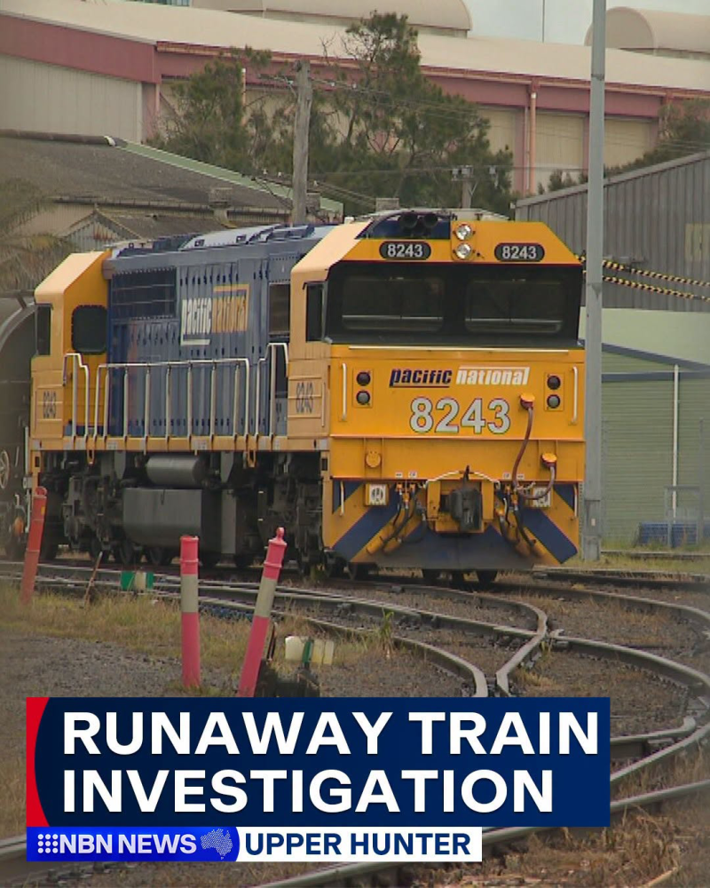 Yellow and blue Pacific National locomotive numbered 8243 on curved railway tracks, with a bottom news banner reading 'RUNAWAY TRAIN INVESTIGATION' (NBN News, Upper Hunter).